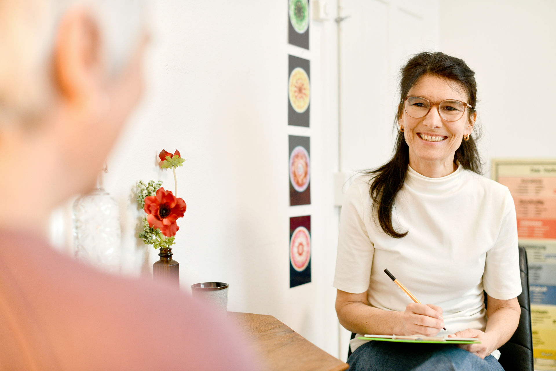 Kinsesiologin Pascale Hauser bei einem beratenden Gespräch mit einer Patientin in ihrer Praxis in Winterthur. Die Atmosphäre ist freundschaftlich und gelöst.